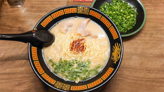 黒と朱色の丼に入った、赤いタレがのった豚骨ラーメン