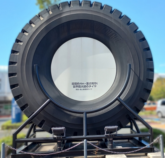 側面にBRIDGESTONEの文字が入った、直径約4mの建設・鉱山車両用の巨大なタイヤ
